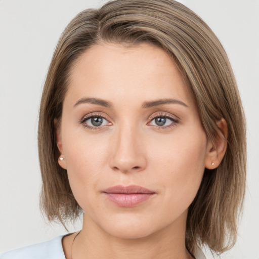 Joyful white young-adult female with medium  brown hair and grey eyes