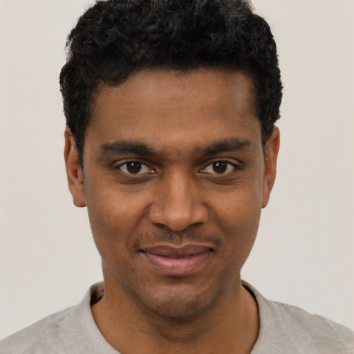 Joyful black young-adult male with short  black hair and brown eyes