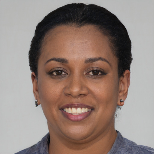 Joyful black young-adult female with short  black hair and brown eyes