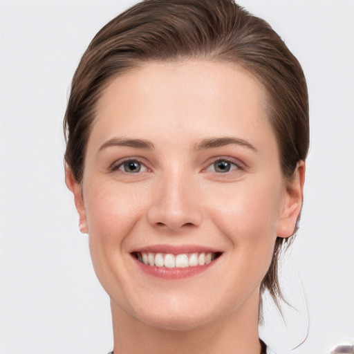 Joyful white young-adult female with short  brown hair and grey eyes