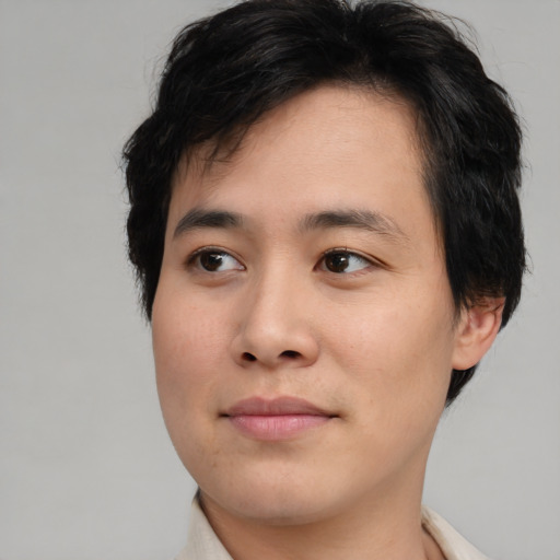 Joyful asian young-adult male with medium  brown hair and brown eyes