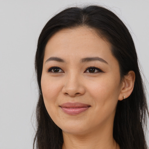 Joyful asian young-adult female with long  brown hair and brown eyes