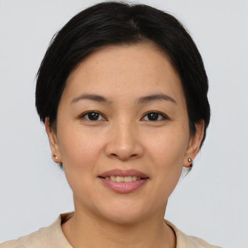 Joyful asian young-adult female with short  brown hair and brown eyes