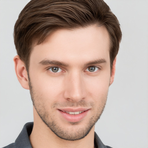 Joyful white young-adult male with short  brown hair and grey eyes