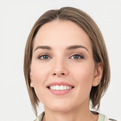 Joyful white young-adult female with medium  brown hair and green eyes