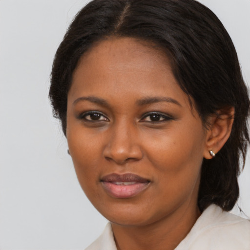 Joyful black young-adult female with medium  brown hair and brown eyes