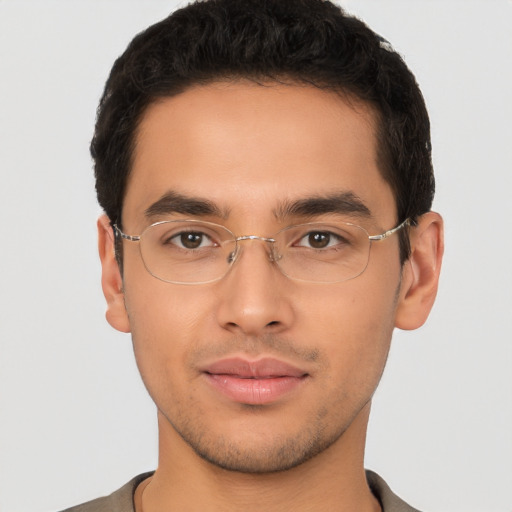 Joyful latino young-adult male with short  brown hair and brown eyes