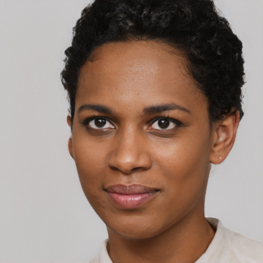 Joyful black young-adult female with short  black hair and brown eyes