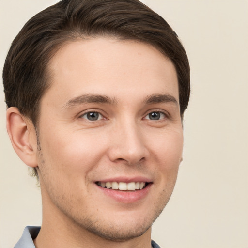 Joyful white young-adult male with short  brown hair and brown eyes