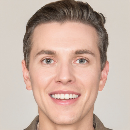 Joyful white young-adult male with short  brown hair and grey eyes