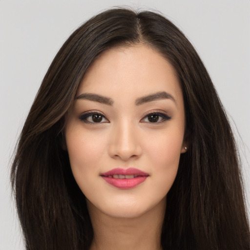 Joyful asian young-adult female with long  brown hair and brown eyes