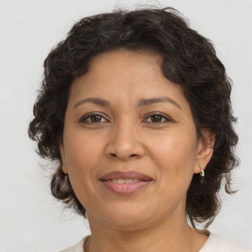 Joyful latino adult female with medium  brown hair and brown eyes
