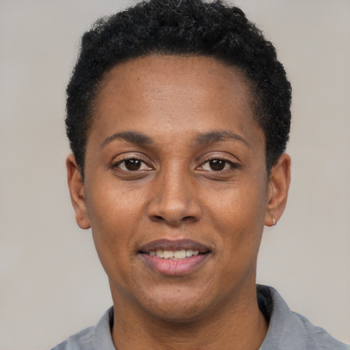 Joyful black adult female with short  black hair and brown eyes