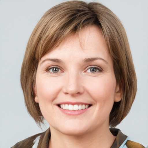 Joyful white young-adult female with medium  brown hair and green eyes