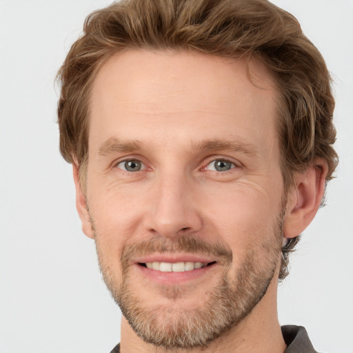 Joyful white adult male with short  brown hair and grey eyes