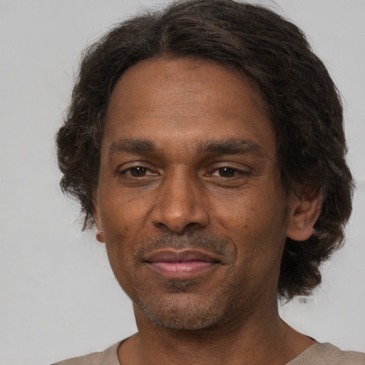 Joyful black adult male with short  brown hair and brown eyes