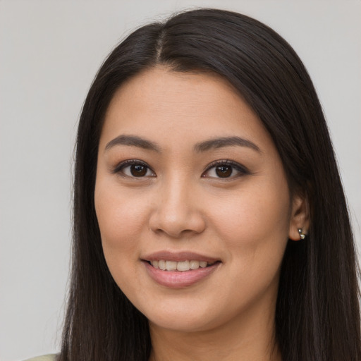 Joyful latino young-adult female with long  brown hair and brown eyes