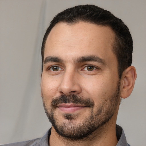 Joyful white adult male with short  black hair and brown eyes