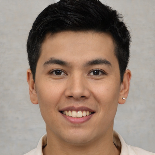 Joyful latino young-adult male with short  brown hair and brown eyes