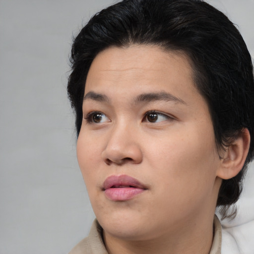 Joyful asian young-adult female with medium  brown hair and brown eyes