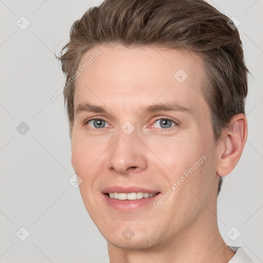 Joyful white adult male with short  brown hair and grey eyes