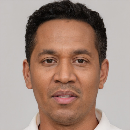 Joyful latino adult male with short  black hair and brown eyes