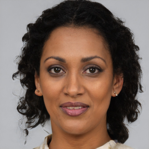 Joyful black adult female with medium  brown hair and brown eyes