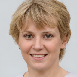 Joyful white young-adult female with medium  brown hair and blue eyes