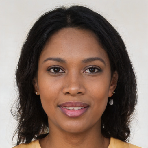 Joyful black young-adult female with long  brown hair and brown eyes