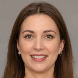 Joyful white adult female with long  brown hair and grey eyes