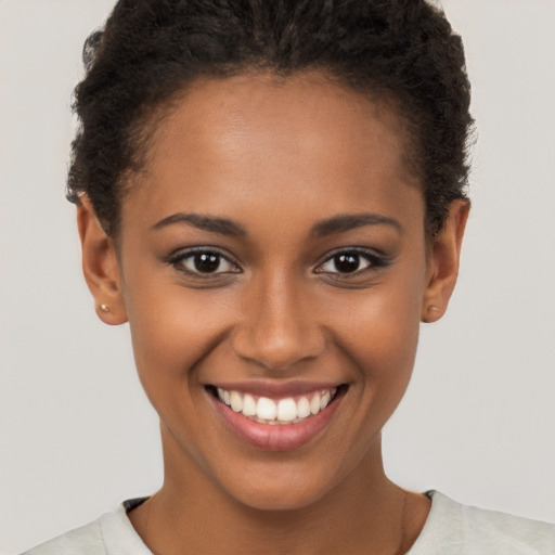 Joyful black young-adult female with short  brown hair and brown eyes