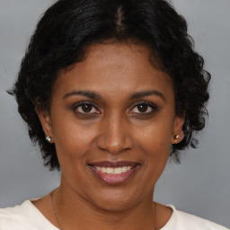 Joyful black adult female with medium  brown hair and brown eyes