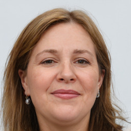 Joyful white adult female with long  brown hair and grey eyes