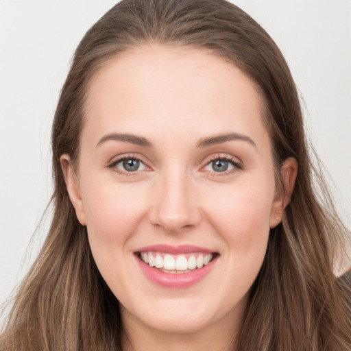 Joyful white young-adult female with long  brown hair and grey eyes