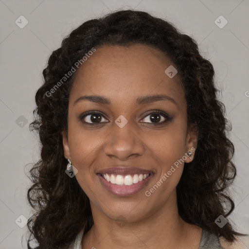 Joyful black young-adult female with long  brown hair and brown eyes