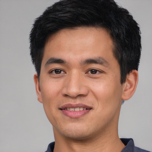 Joyful asian young-adult male with short  black hair and brown eyes