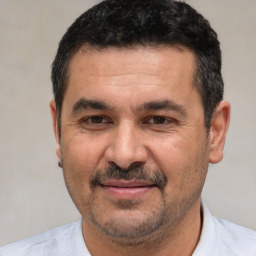 Joyful white adult male with short  black hair and brown eyes