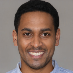 Joyful latino young-adult male with short  black hair and brown eyes