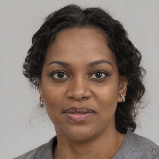 Joyful black adult female with medium  brown hair and brown eyes