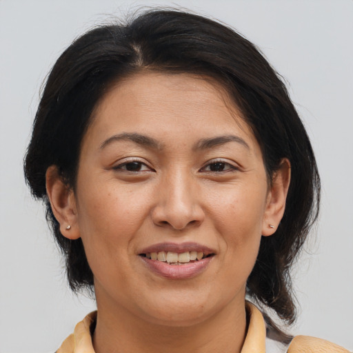 Joyful asian adult female with medium  brown hair and brown eyes