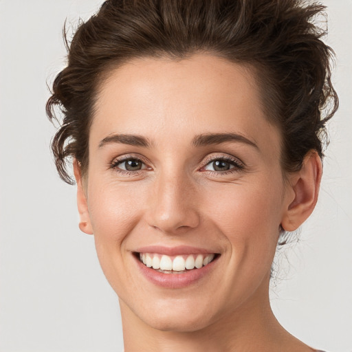 Joyful white young-adult female with medium  brown hair and grey eyes