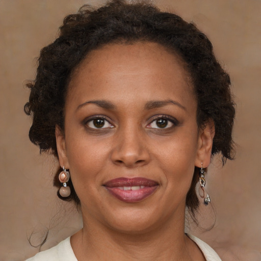 Joyful black adult female with medium  brown hair and brown eyes