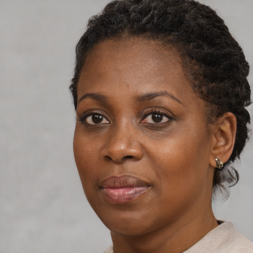 Joyful black adult female with short  brown hair and brown eyes