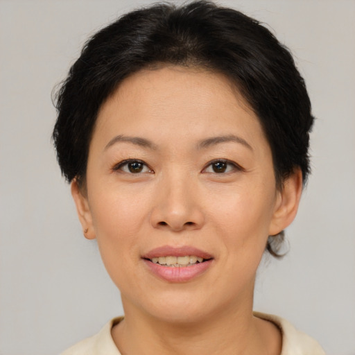 Joyful asian adult female with short  brown hair and brown eyes