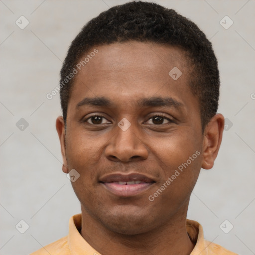 Joyful black young-adult male with short  black hair and brown eyes