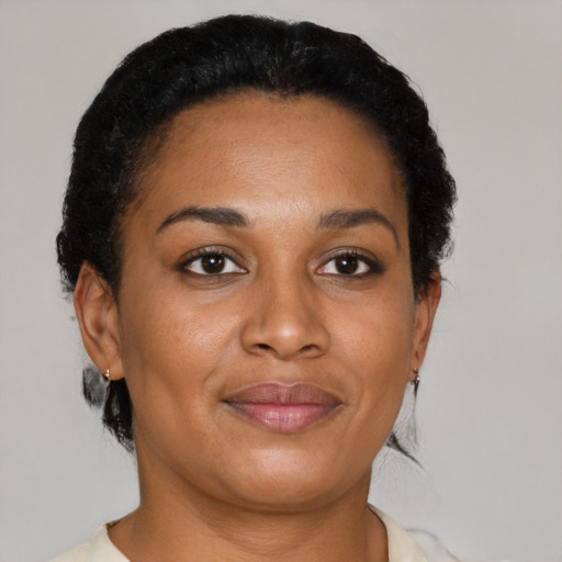 Joyful black adult female with short  brown hair and brown eyes