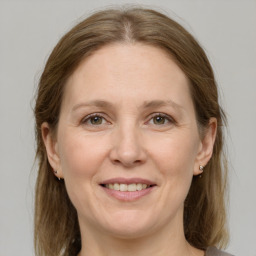 Joyful white adult female with medium  brown hair and grey eyes