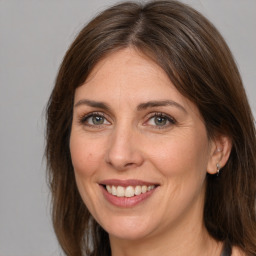 Joyful white adult female with medium  brown hair and brown eyes