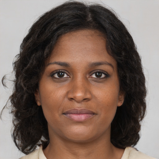 Joyful black young-adult female with medium  brown hair and brown eyes