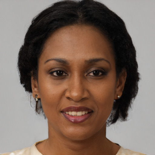 Joyful black adult female with short  brown hair and brown eyes